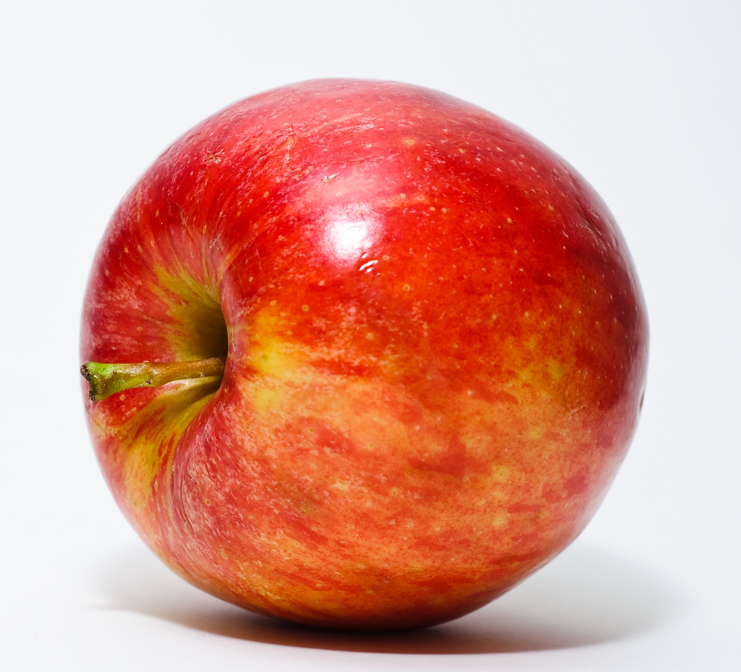 Shiny red apple with applied wax coating — the gloss is artificial wax, not the fruit’s natural surface