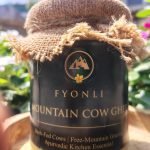 Fyonli Mountain Cow Ghee 400g on wooden platform – garden background